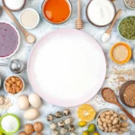 A collection of the most nutrient-dense foods including salmon, kale, blueberries, eggs, and nuts on a wooden table